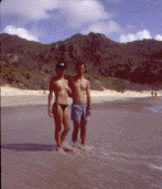 Photo of a couple on a beach
with a long empty stretch of sand in the background.
